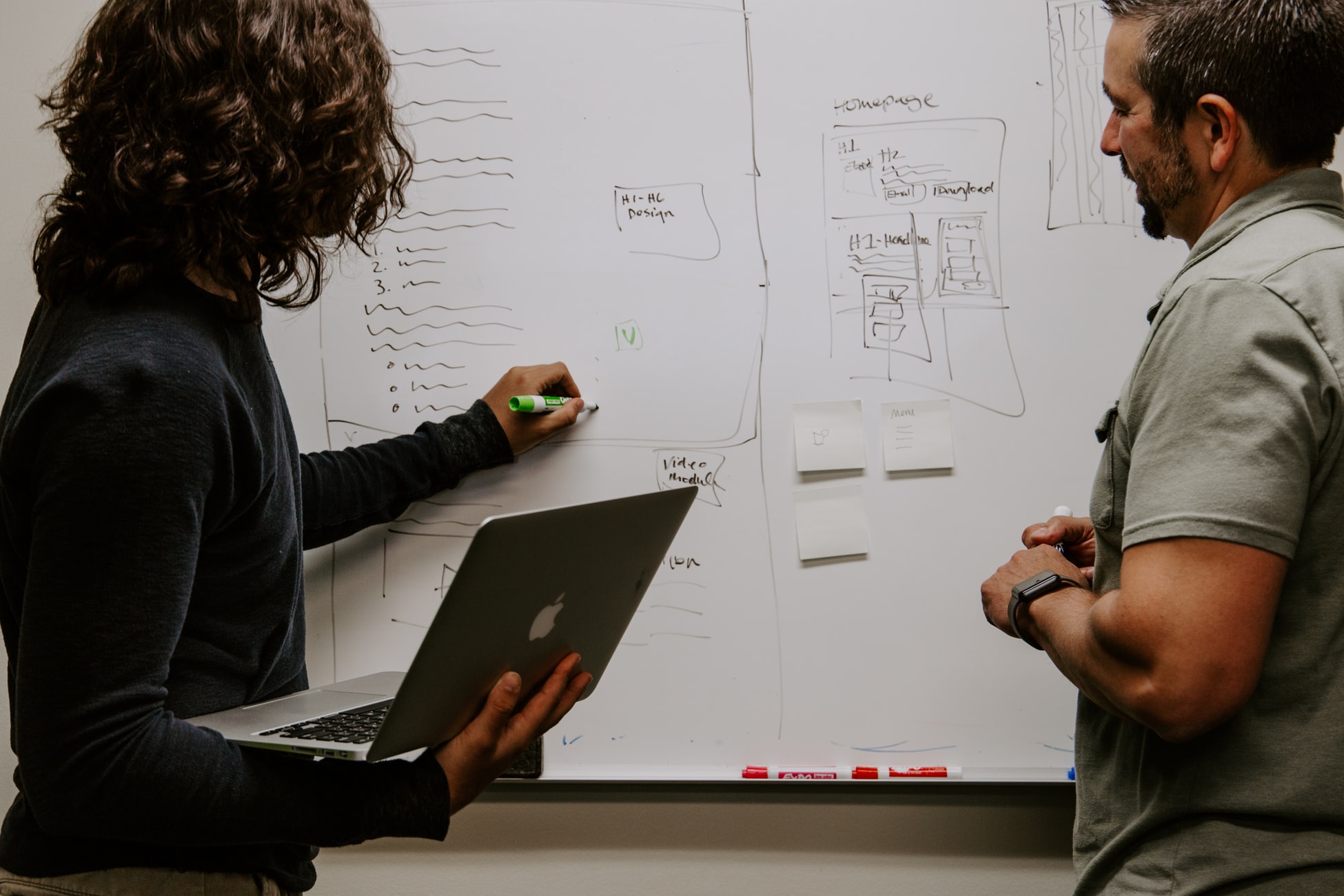 Photo by Kaleidico on Unsplash Two people drawing on a whiteboard
